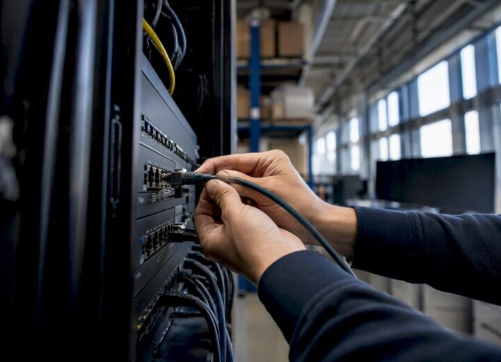 Hands plugging cable into industrial network switch